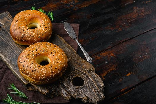 Fresh Bagels with Sesame, on old dark wooden table background, with copy space for text