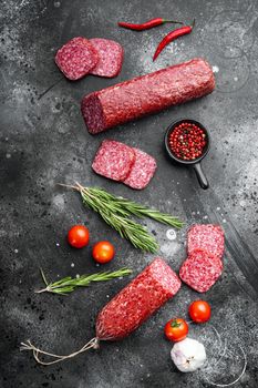 Salami with herbs , garlic set, on black dark stone table background, top view flat lay