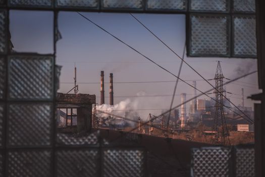 abandoned place with industrial background. Industrial zone view on pipes with smoke. Air pollution in the city