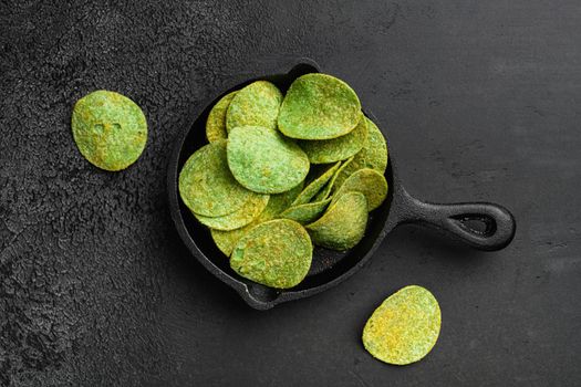 Green Chile Limon Flavored Potato Chips, on black dark stone table background, top view flat lay