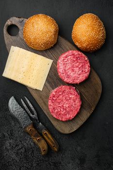 Raw Ground beef meat Burger patties, on black dark stone table background, top view flat lay