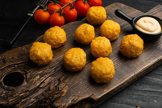 Battered meatballs, on black wooden table background