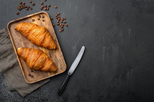 Fresh croissants on table, on black dark stone table background, top view flat lay, with copy space for text