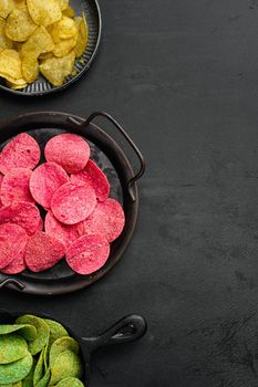 Variation different potato chips, on black dark stone table background, top view flat lay, with copy space for text