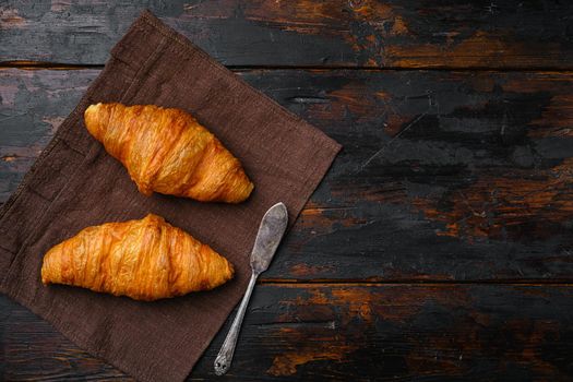 Fresh baked croissant, on old dark wooden table background, top view flat lay, with copy space for text