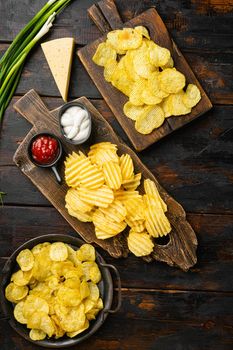 Sour Cream Onion Flavored Potato Chips, on old dark wooden table background, top view flat lay