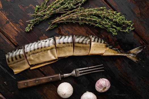 Whole smoked mackerel fish set, on old dark wooden table background, top view flat lay