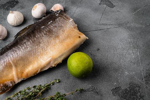 Whole smoked trout fish set, on gray stone table background, with copy space for text