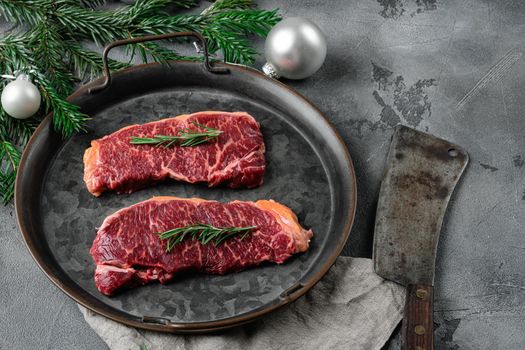 Christmas style New York beef steak cut set, on gray stone table background, with copy space for text