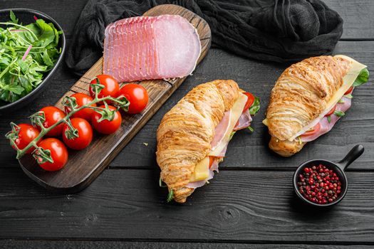Breakfast, business lunch, sandwiches Croissant set, with herbs and ingredients, on black wooden table background