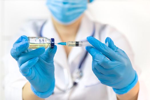 Doctor filling syringe with medication, closeup. Vaccination and immunization. Selective focus. Vaccine.