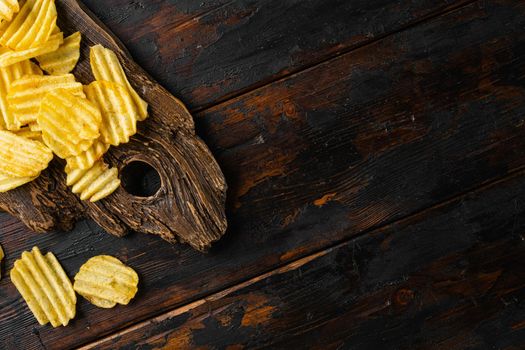 Wavy Ranch Flavored Potato Chips, on old dark wooden table background, top view flat lay, with copy space for text