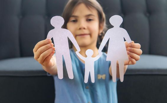 Child with a paper family in his hands. Selective focus. People.