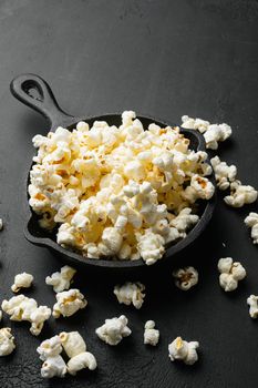 Salted popcorn, on black dark stone table background