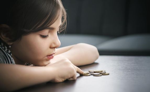 Child counts coins, poverty concept. Selective focus People