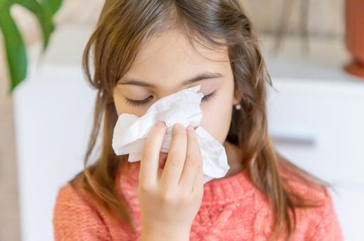 The child wipes a runny nose with a napkin. Selective focus. People.