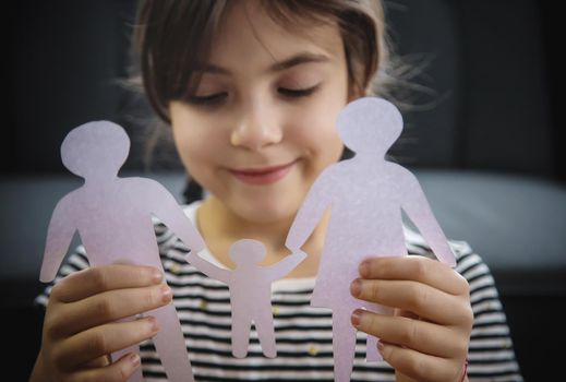 Child with a paper family in his hands. Selective focus. People.