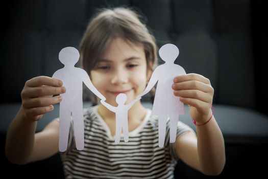 Child with a paper family in his hands. Selective focus. People.