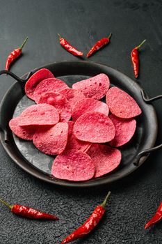 Hot Flavored Potato Chips, on black dark stone table background