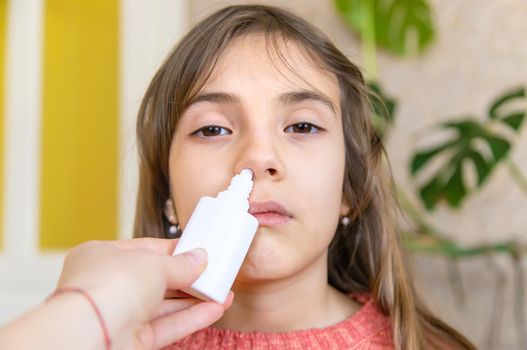 Mother drips medicine into the child nose. Selective focus. People.