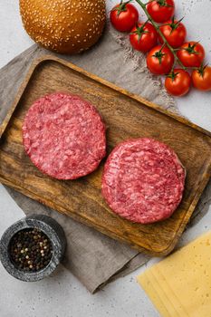 Raw BBQ Beef Burger Cutlets, on gray stone table background, top view flat lay