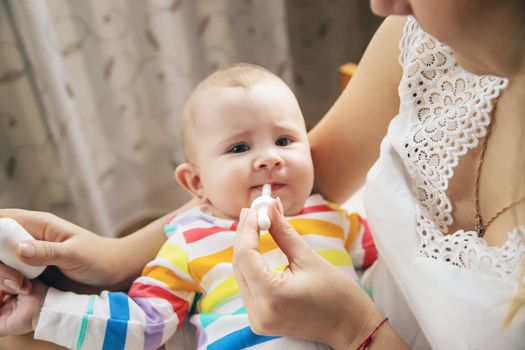 mother gives colic medicine to little baby. Selective focus. child.