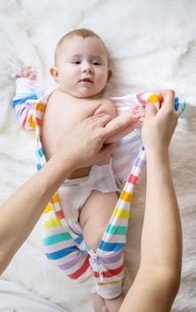 mother dresses her little baby. Selective focus. child.