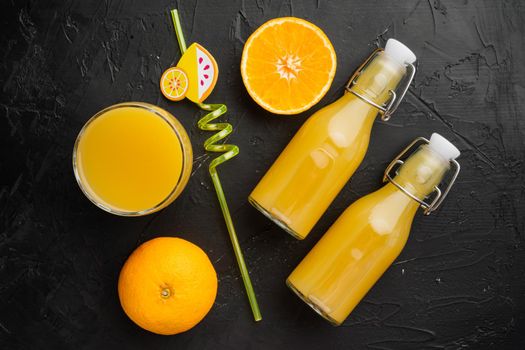 Fresh orange juice set, on black dark stone table background, top view flat lay
