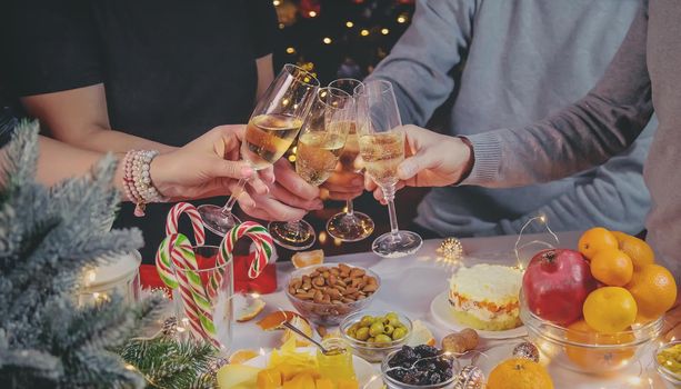 Champagne in hand against the background of the Christmas tree. People. Selective focus. Holiday.