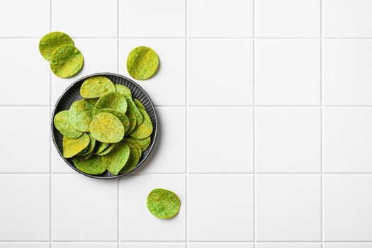 Green Chile Limon Flavored Potato Chips, on white ceramic squared tile table background, top view flat lay, with copy space for text