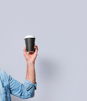 Close up of hand holding a paper cup of coffee. Hand holding a coffee to go on isolated background, Arm holding glass of coffee isolated