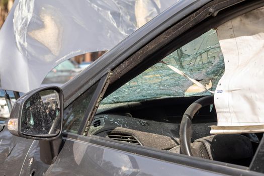 Shot car during the war in Ukraine. A car after an accident with a broken rear window. The wreckage of the interior of a modern car after an accident, a detailed close-up view of the damaged car