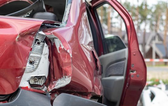 Red car after a terrible accident on the side of the road. Frontal and side impact. Life insurance. An accident without the possibility of recovery. Back view. Damage after an accident