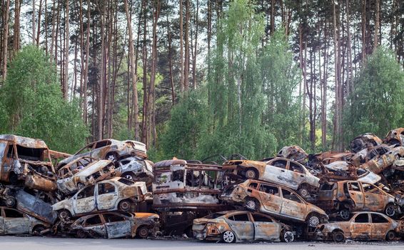 A lot of rusty burnt cars in Irpen, after being shot by the Russian military. Russia's war against Ukraine. Cemetery of destroyed cars of civilians who tried to evacuate from the war zone