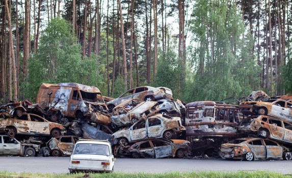 A lot of rusty burnt cars in Irpen, after being shot by the Russian military. Russia's war against Ukraine. Cemetery of destroyed cars of civilians who tried to evacuate from the war zone