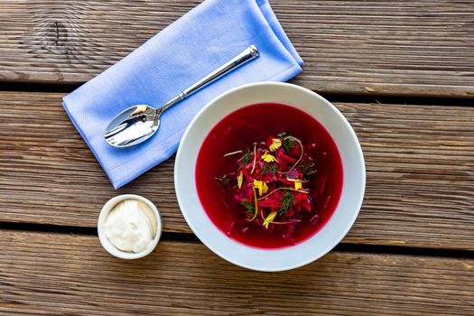 Vegetable cold soup with beet, cucumber, radsih and egg on wooden table.