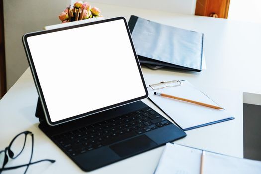 A white screen tablet computer placed on the desk at work. Can put text or media in the area on the white screen