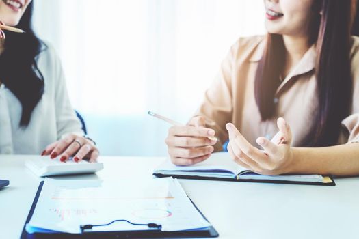 Negotiation, Analysis, Discussion, Asian woman economist and marketer pointing to a financial data sheet to plan investments to prevent risks and losses for the company.