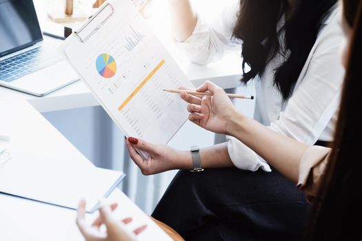 Negotiation, Analysis, Discussion: Portrait of an Asian woman economist and marketer pointing to a financial data sheet to plan investments to prevent risks and losses for the company.