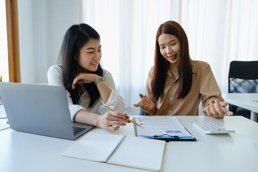 Negotiation, Analysis, Discussion: Portrait of an Asian woman economist and marketer pointing to a financial data sheet to plan investments to prevent risks and losses for the company.