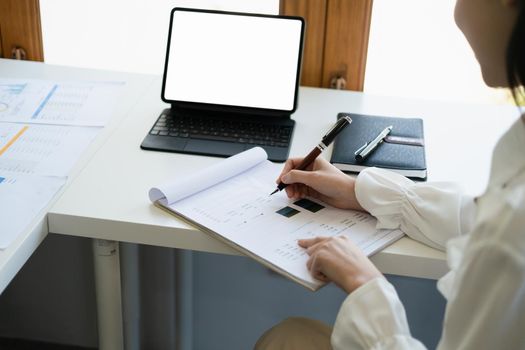 Young economists or accountants or financiers and investors are reviewing budget documents and using computers to study impact and risk assessments on corporate investment management