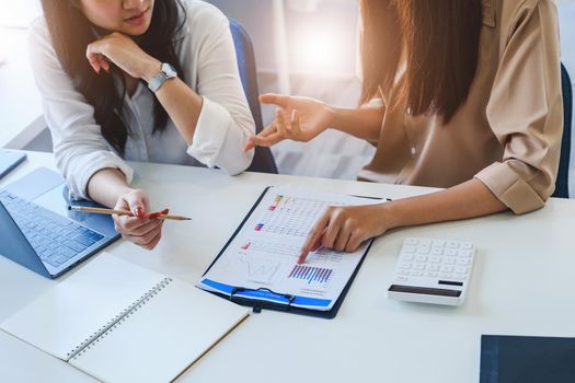 Negotiation, Analysis, Discussion, Asian woman economist and marketer pointing to a financial data sheet to plan investments to prevent risks and losses for the company.