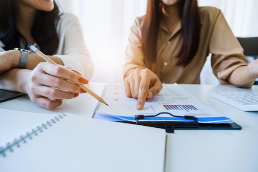 Negotiation, Analysis, Discussion, Asian woman economist and marketer pointing to a financial data sheet to plan investments to prevent risks and losses for the company.