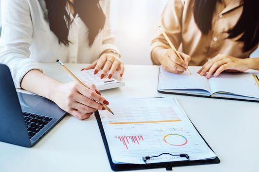 Negotiation, Analysis, Discussion, Asian woman economist and marketer pointing to a financial data sheet to plan investments to prevent risks and losses for the company.