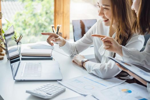 Negotiation, Analysis, Discussion, Asian woman economist and marketer using computer laptop to plan investments and financial to prevent risks and losses for the company.