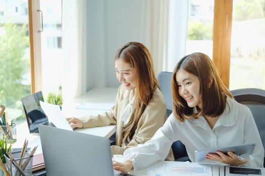 Negotiation, Analysis, Discussion, Portrait of an Asian woman economist and marketer using computer laptop to plan investments and financial to prevent risks and losses for the company.