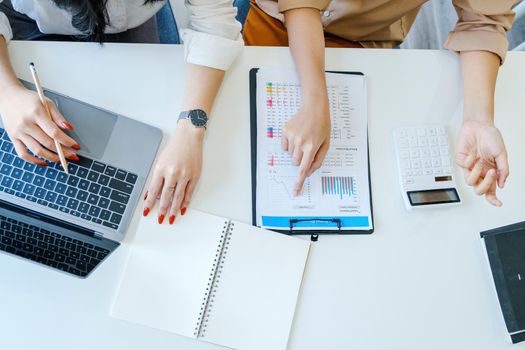 Negotiation, Analysis, Discussion, Asian woman economist and marketer pointing to a financial data sheet to plan investments to prevent risks and losses for the company.