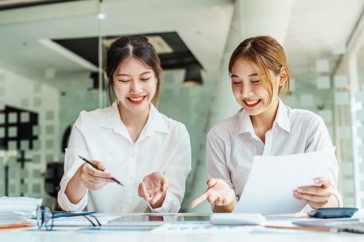 Negotiation, Analysis, Discussion, Portrait of an Asian women economist and marketer using tablet computer to plan investments and financial to prevent risks and losses for the company.