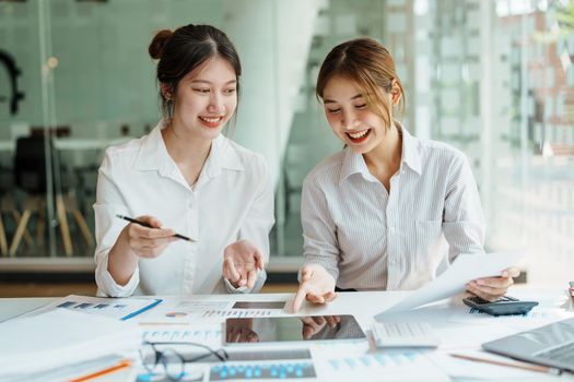 Negotiation, Analysis, Discussion, Portrait of an Asian women economist and marketer using tablet computer to plan investments and financial to prevent risks and losses for the company.