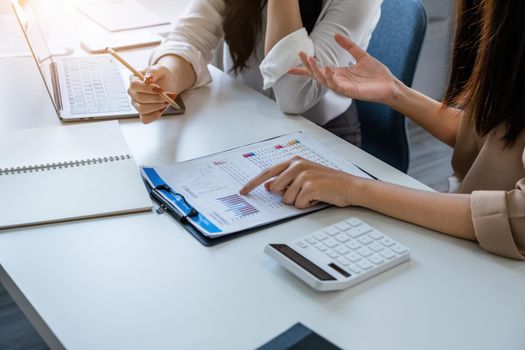 Negotiation, Analysis, Discussion, Asian woman economist and marketer pointing to a financial data sheet to plan investments to prevent risks and losses for the company.